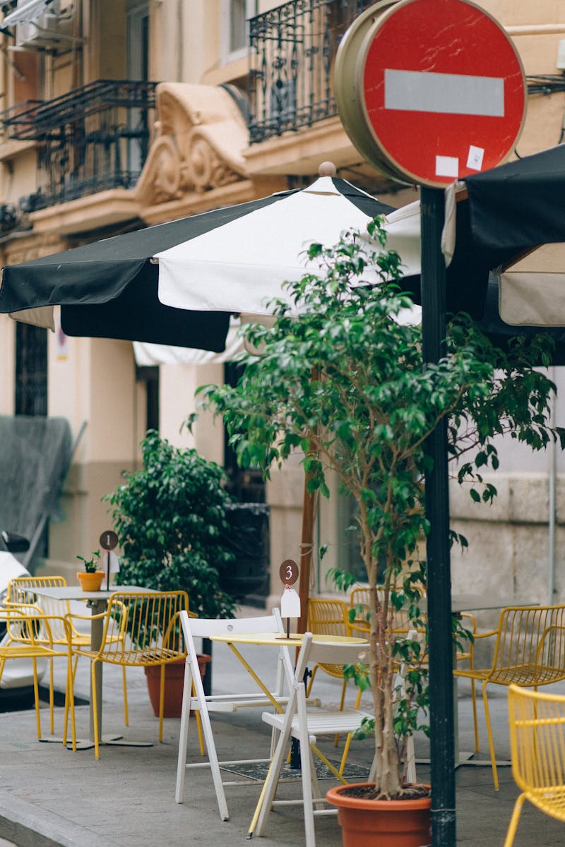 Cozy outdoor cafe setting with colorful chairs and signage on urban street