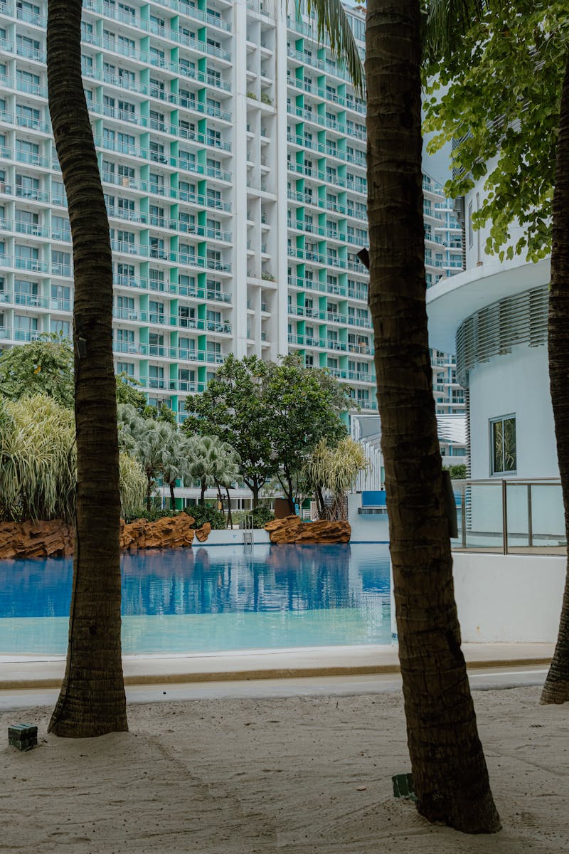 High-rise condominium overlooking tropical swimming pool with lush greenery in Malaysia