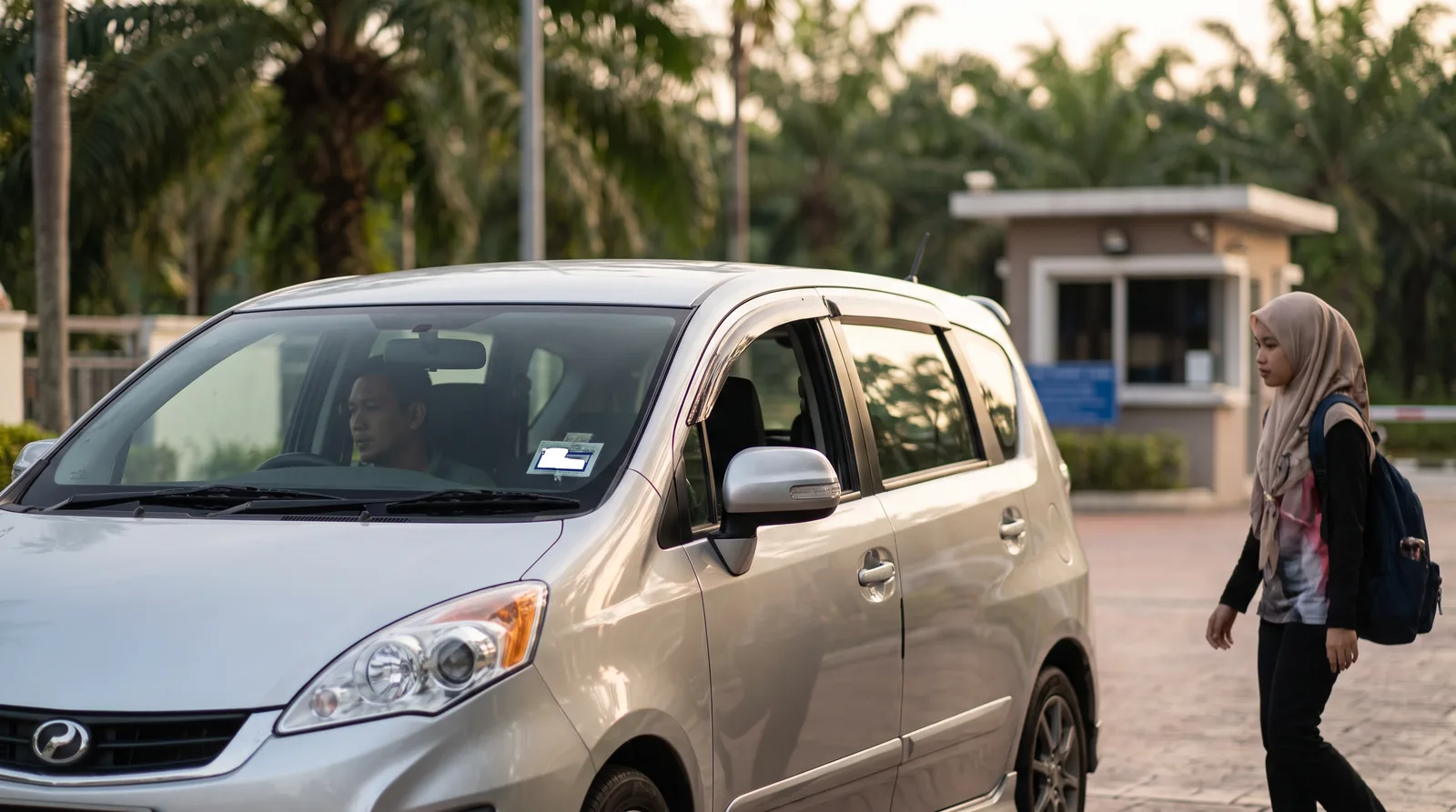E-hailing car at a Malaysian condo pickup point with a small e-hailing sticker on the front windscreen