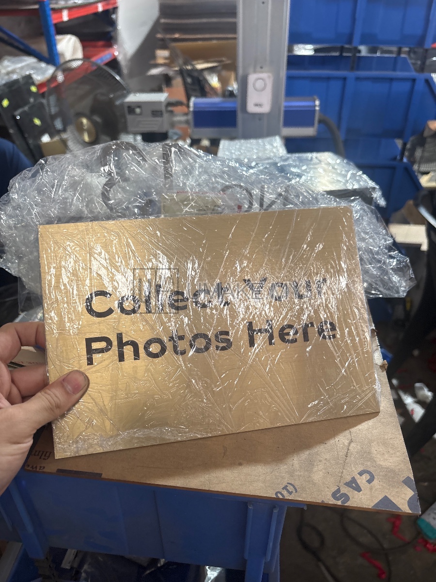 A close-up of a gold-engraved stainless steel signage plate with precise, high-quality direct UV printing and clean laser-cut edges.