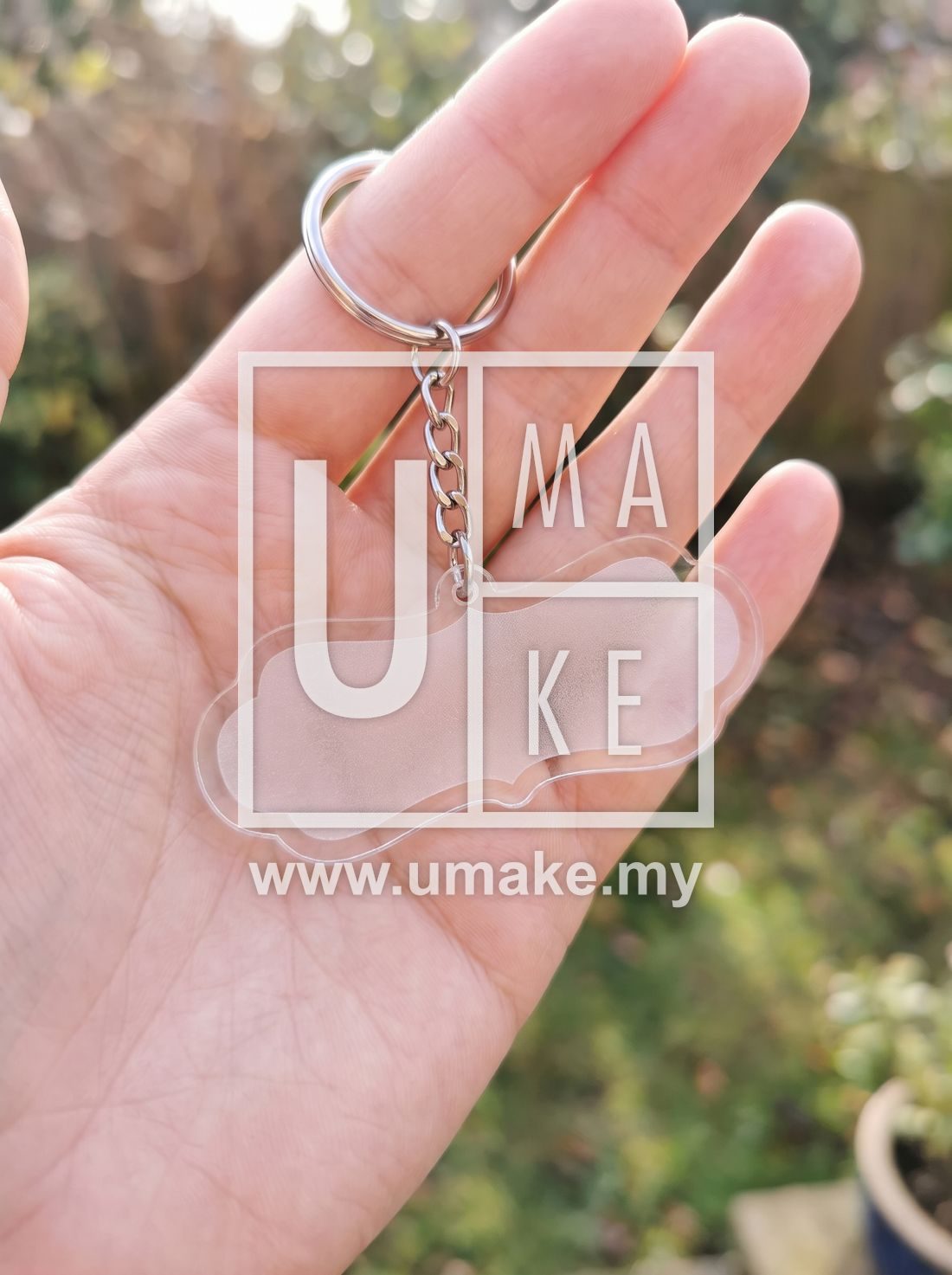 Hand holding a custom-shaped clear acrylic keychain