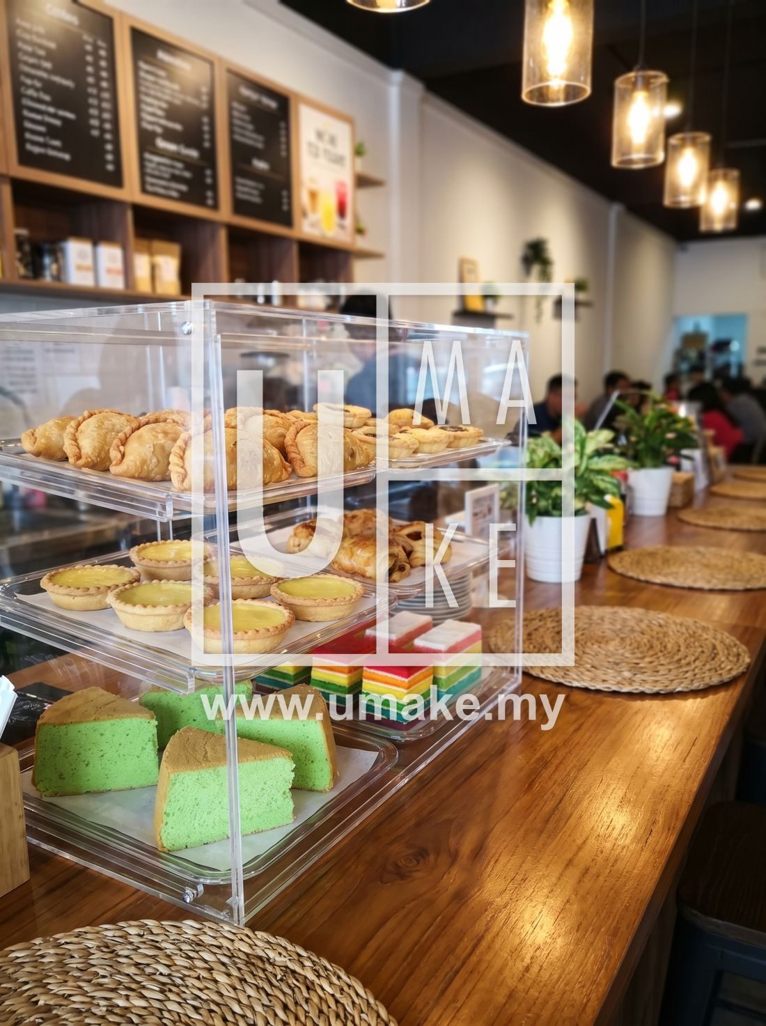 Acrylic food display cabinet showcasing pastries and cakes in a cafe