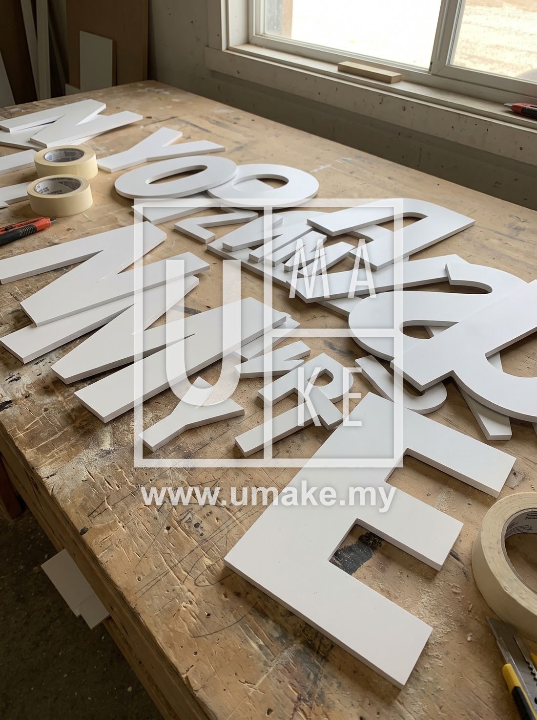 Flat-cut PVC letters laid out on a workbench ready for installation