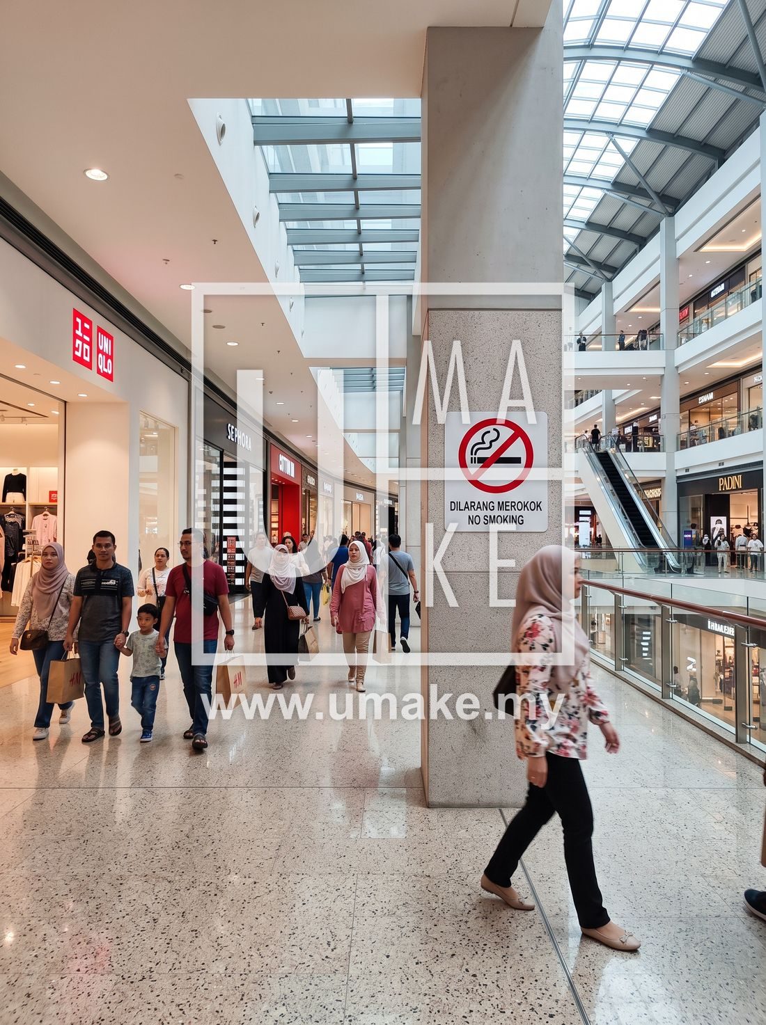Shoppers passing a no smoking sign in a Malaysian shopping mall