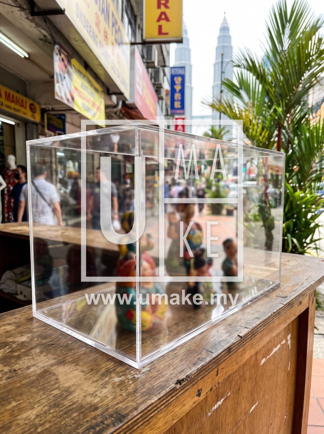 A custom acrylic display case on a shop counter in Kuala Lumpur