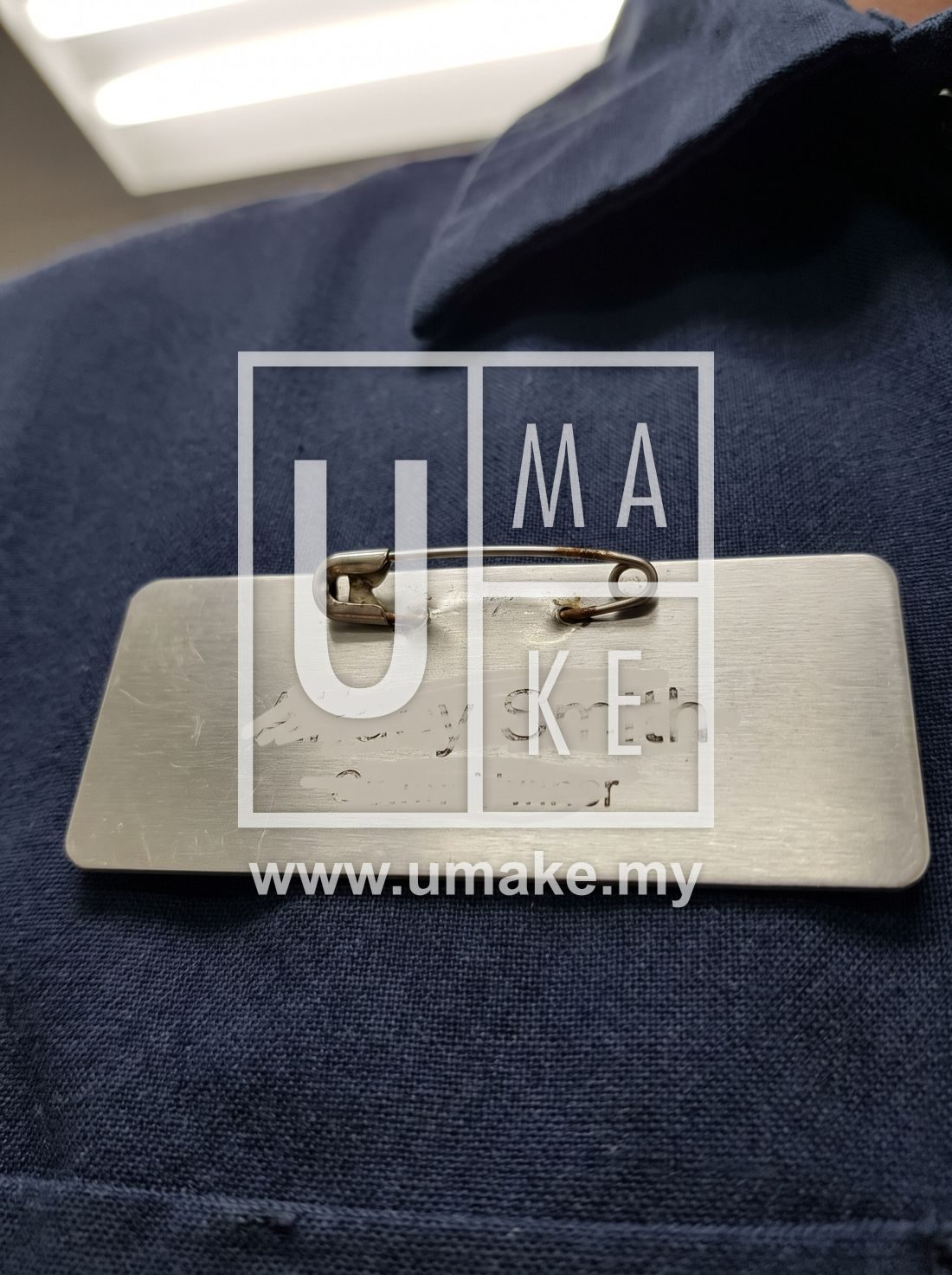 A close-up of a pin-on staff name tag on a uniform