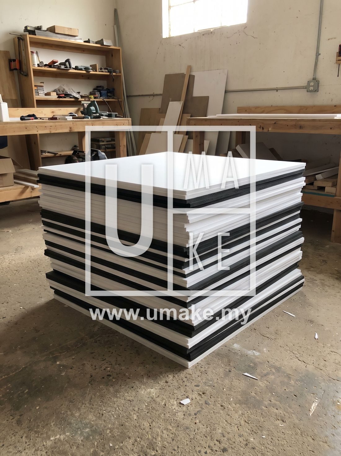 A stack of white and black PVC foam boards in a workshop