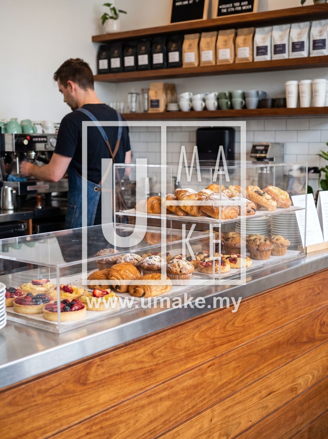 A cafe counter with acrylic display cases of pastries