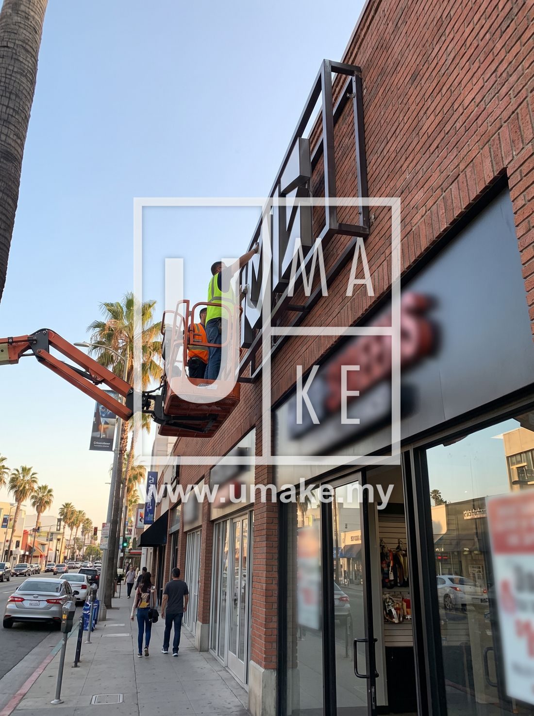 A 3D box-up sign being mounted on a PJ storefront