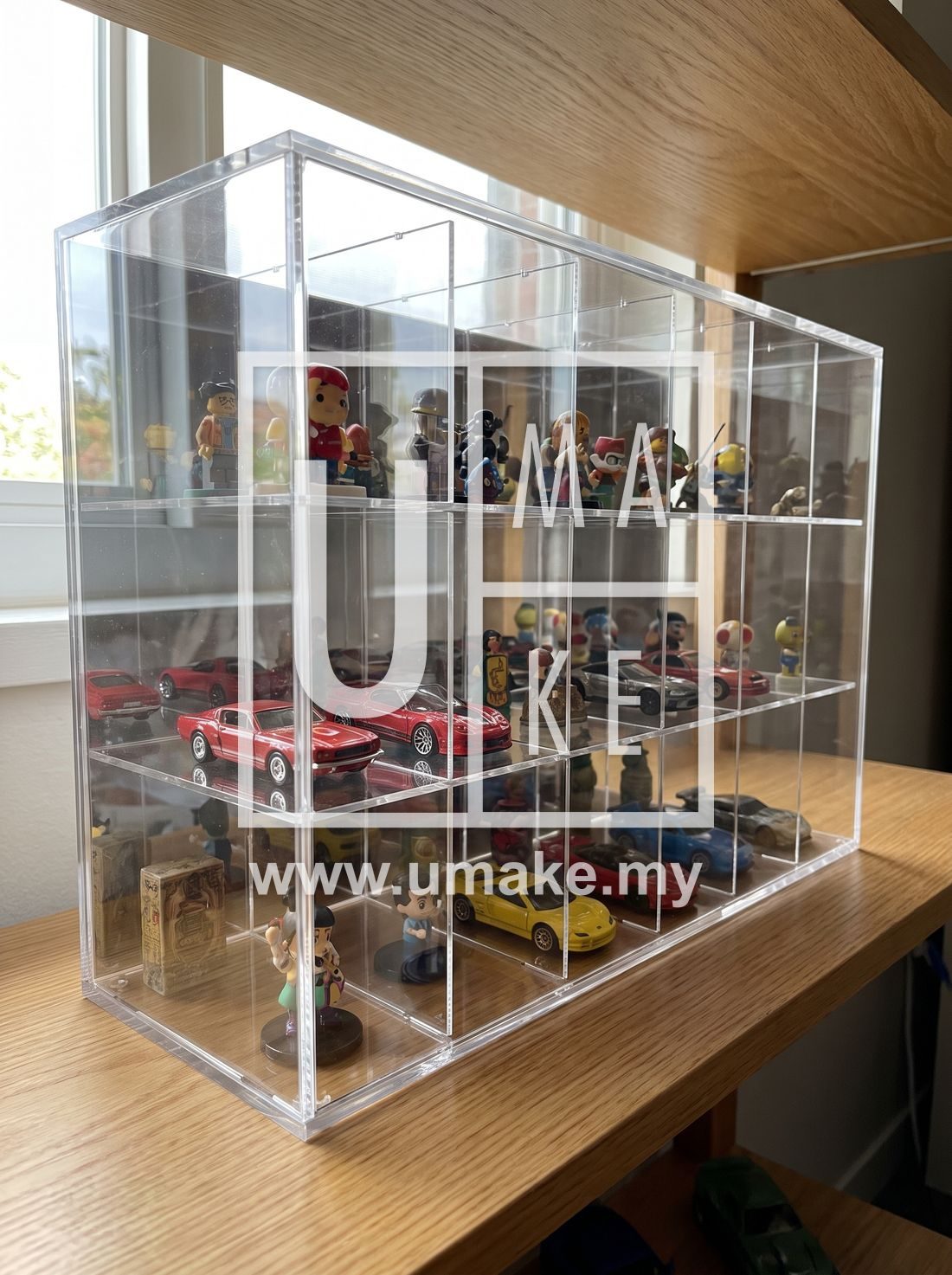 A clear acrylic display case with custom dividers holding collectibles