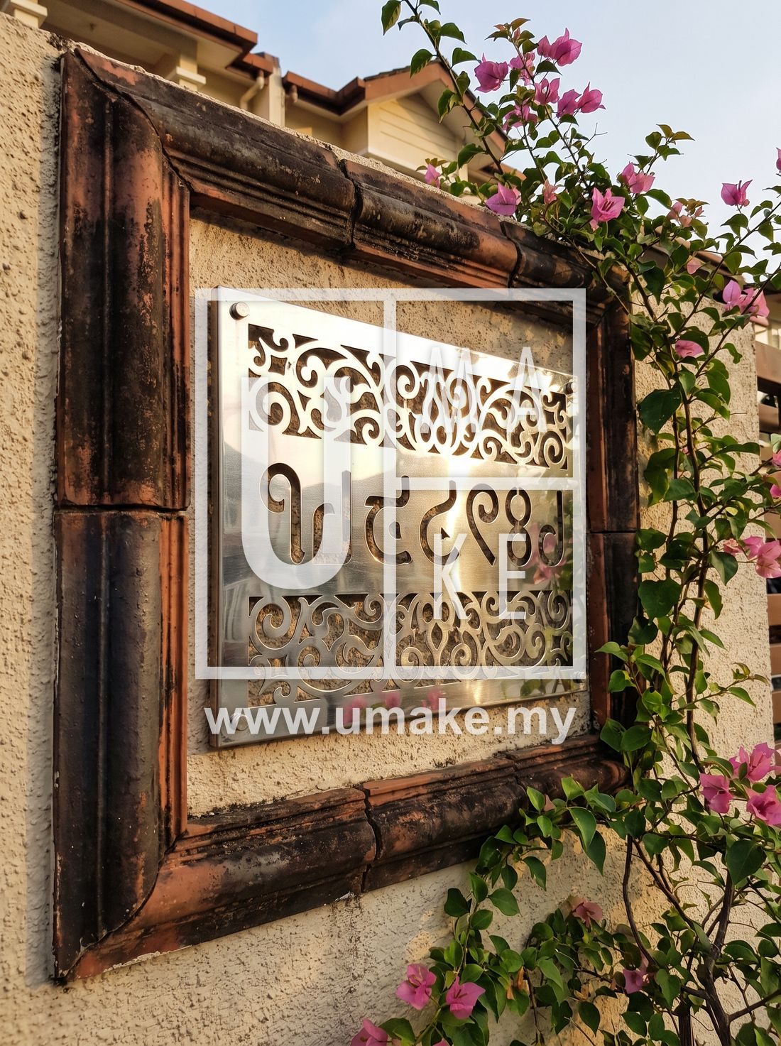 A decorative stainless steel house number plate on a Malaysian Indian home wall