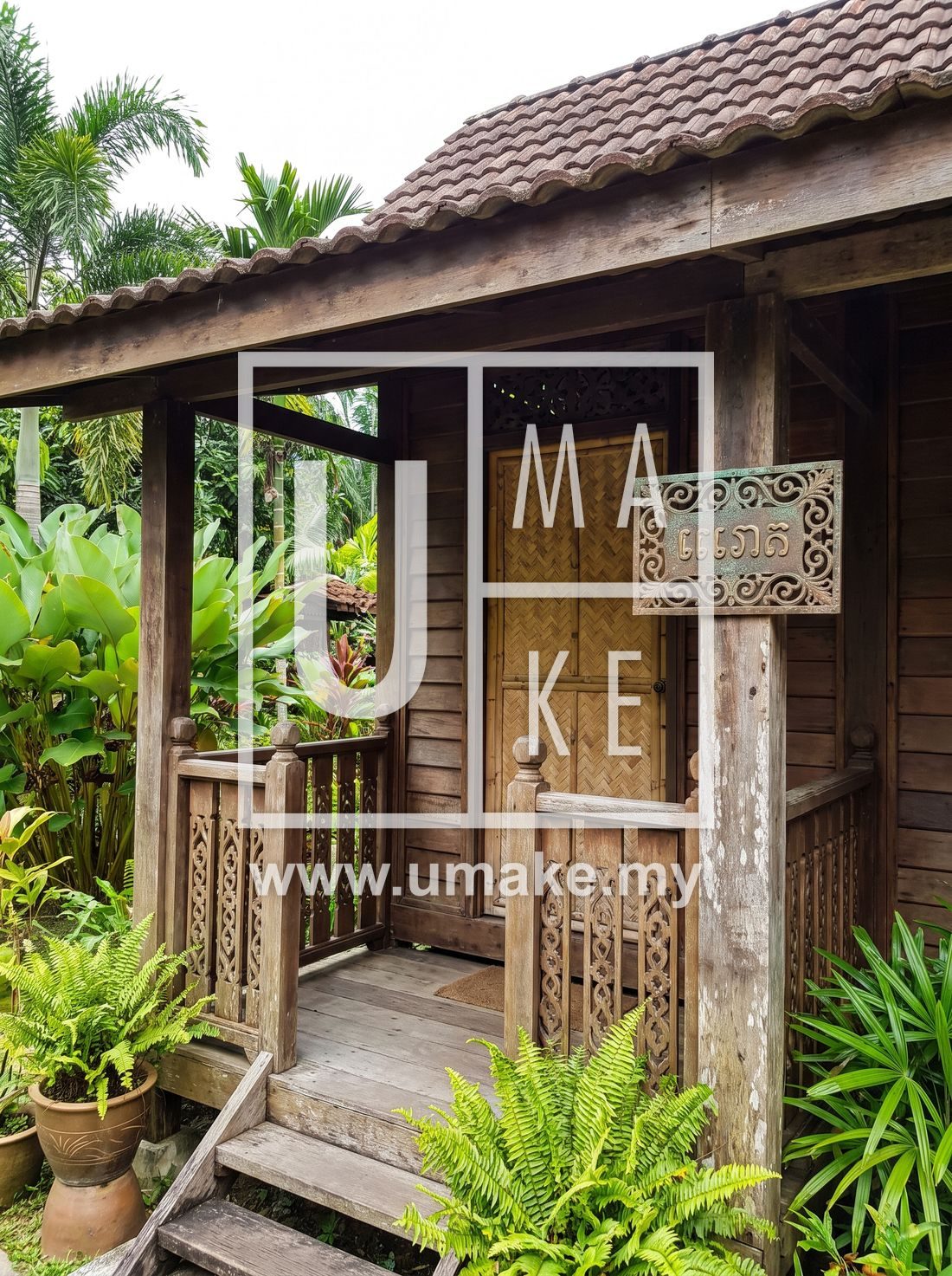 A traditional Malaysian home entrance with an ornate house number plate