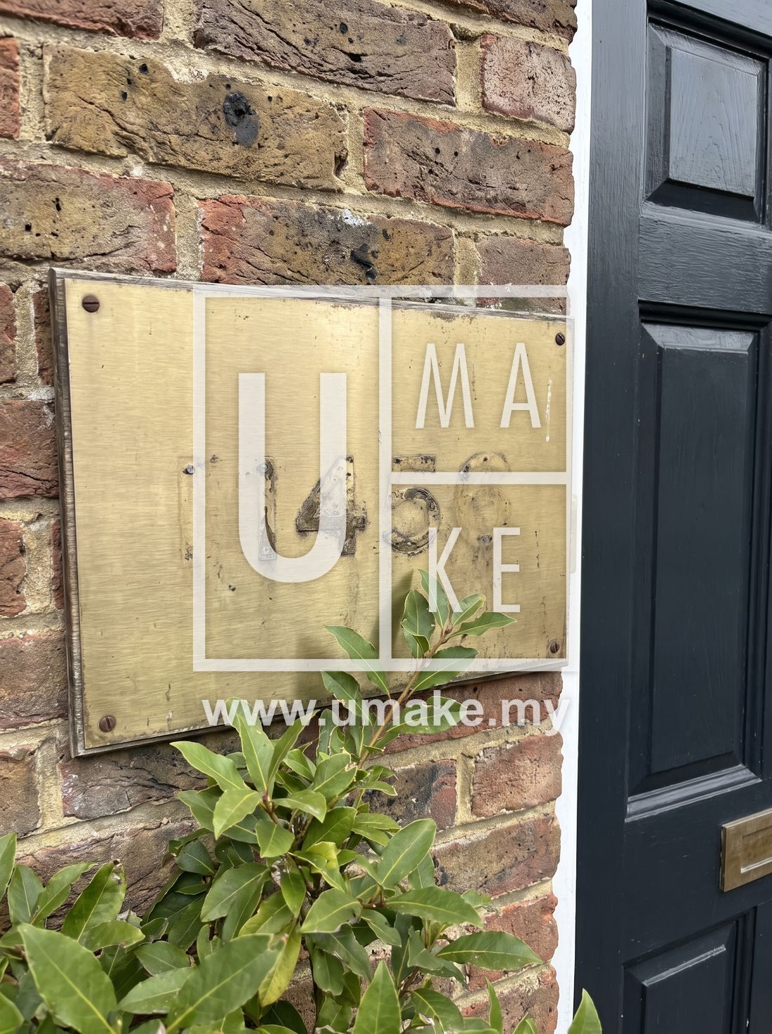 A brass-look house number plate mounted beside a front door