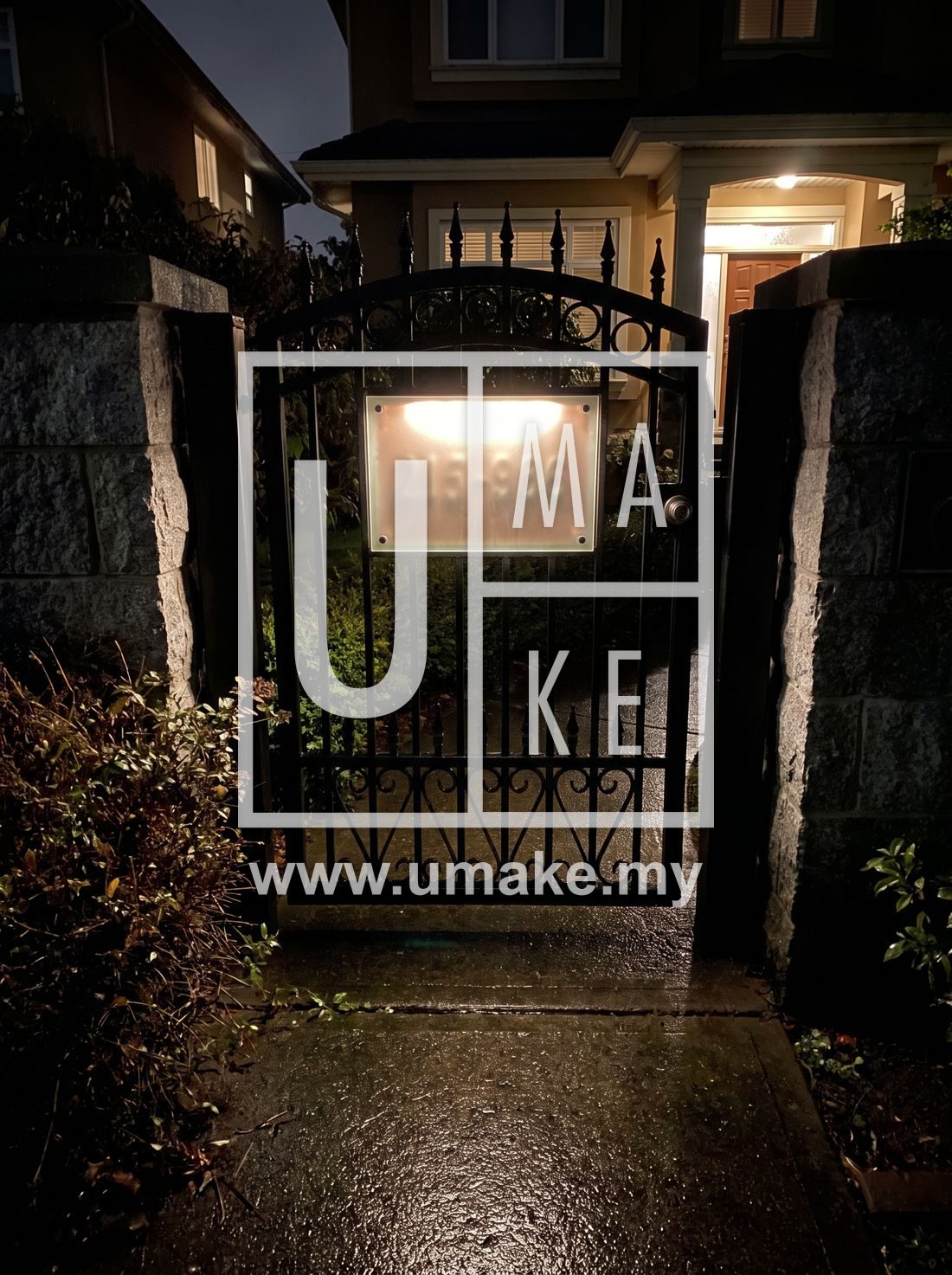 A house gate with a softly glowing address plate at night