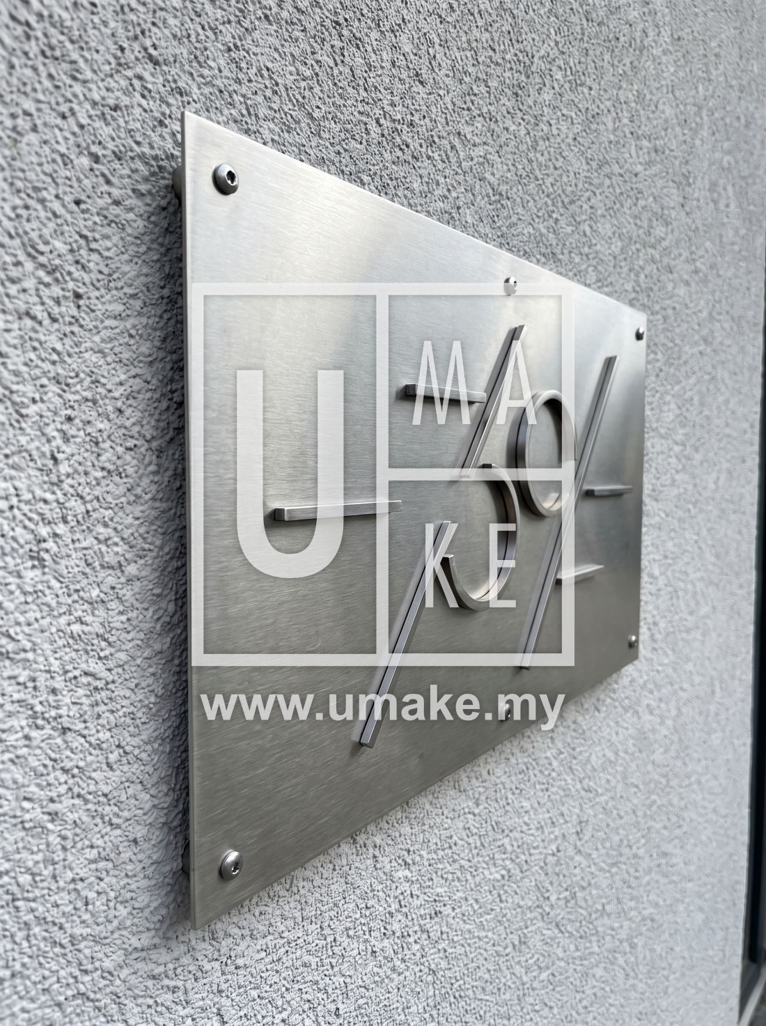 A modern stainless steel house number plate on a rendered wall