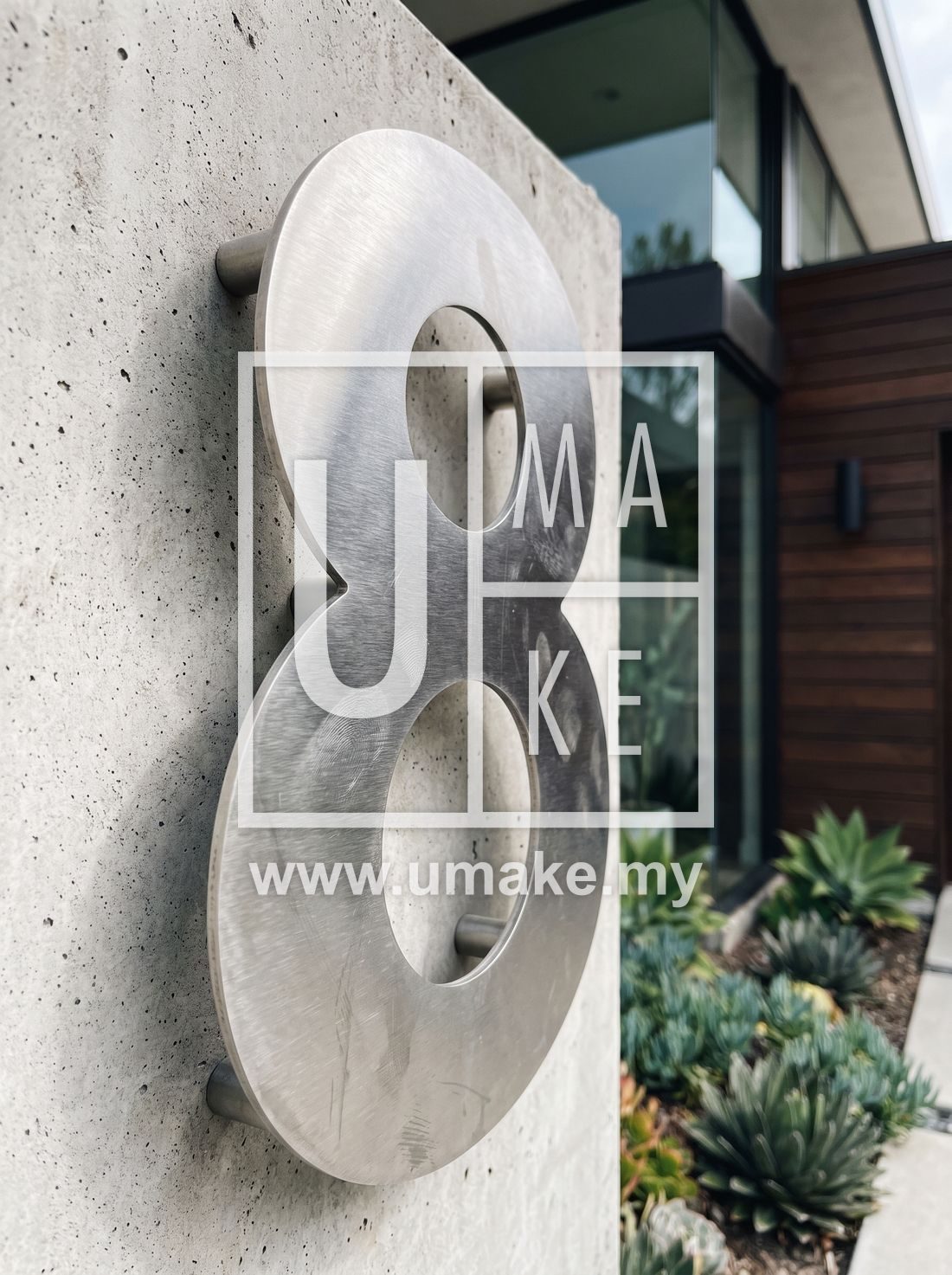A close-up of a brushed steel house number on a modern home