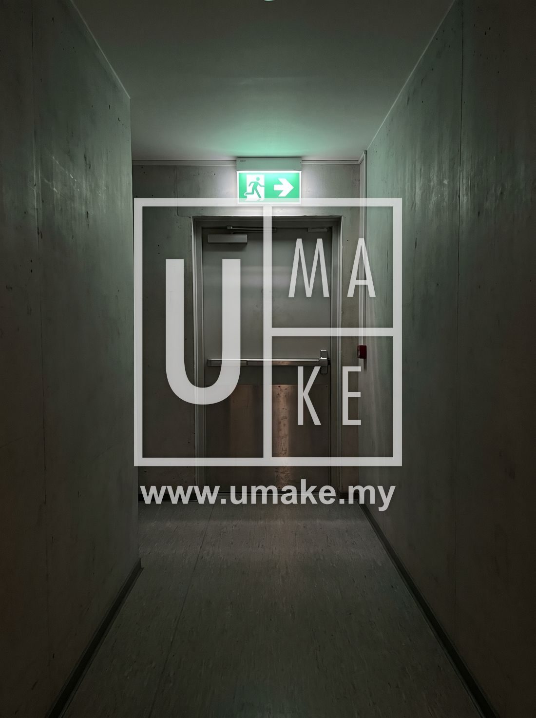 A green emergency exit sign glowing above a corridor door