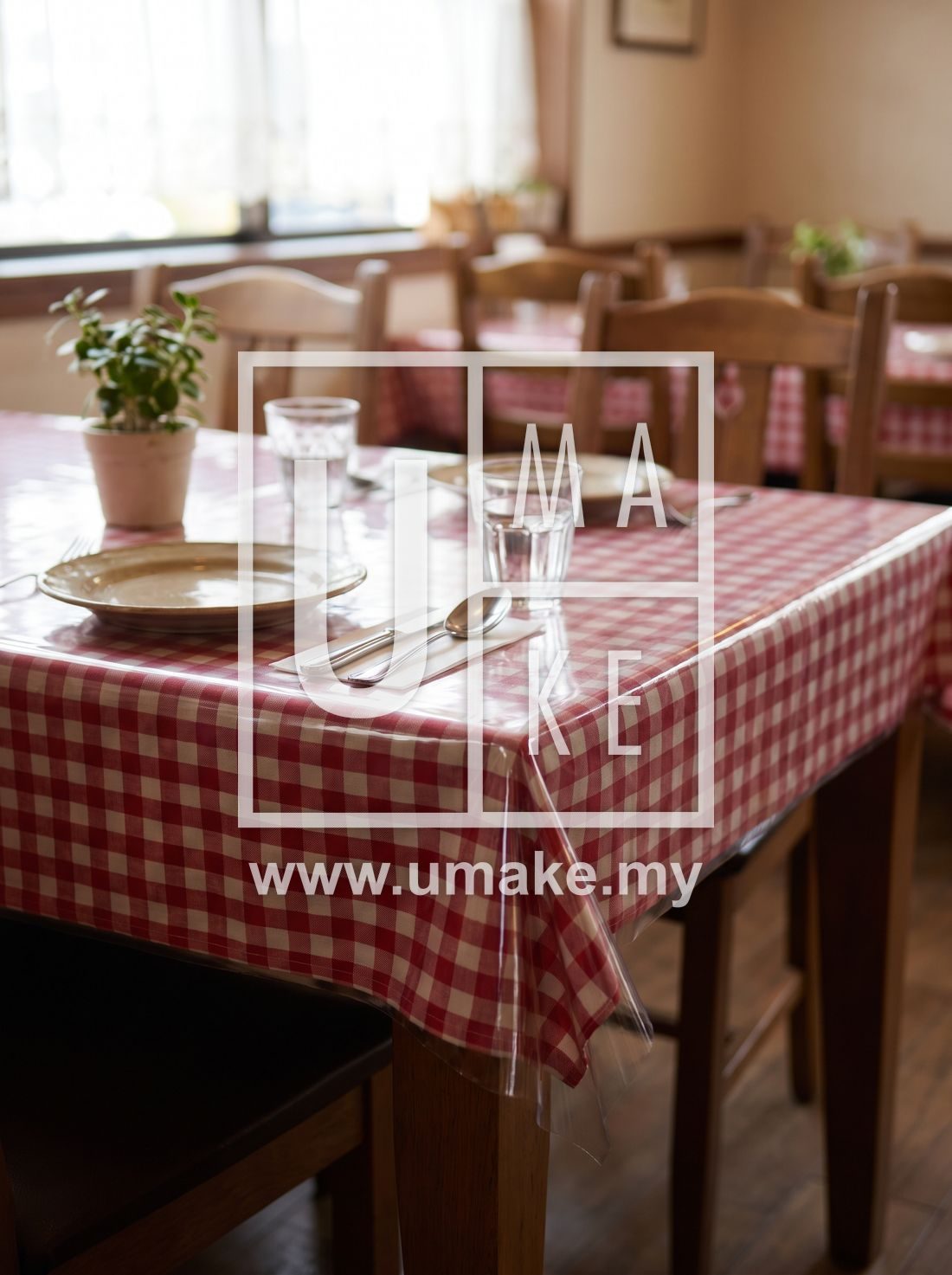 A restaurant table with a clear PVC cover over a tablecloth