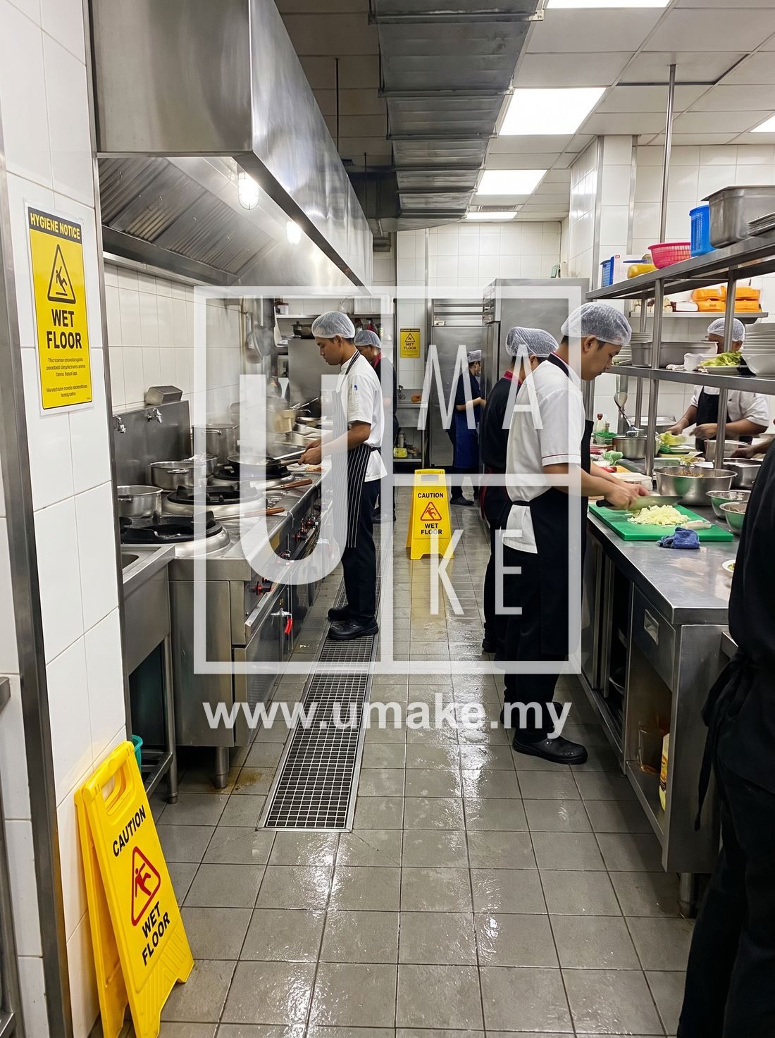 Commercial kitchen with hygiene and wet floor warning signs